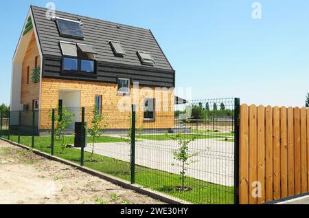 Concept de maison passive. Maison moderne avec isolation, murs en bois, fenêtres de lucarne grenier, panneaux solaires, chauffe-eau solaire sur le toit pour l'énergie SAV Banque D'Images