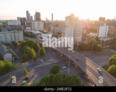 Photographie aérienne du centre-ville de Manchester, campus de l'Université de Manchester, y compris UMIST, Mancunian Way et London Road sous le soleil du soir Banque D'Images