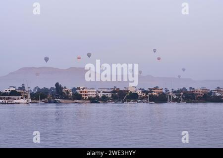 Louxor, Egypte - décembre 26 2023 : montgolfières flottant sur le Nil à Louxor au lever du soleil Banque D'Images