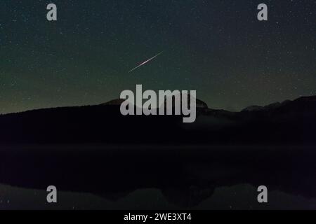 meteor dans le ciel nocturne au-dessus d'un lac noir dans le parc national de Durmitor Banque D'Images