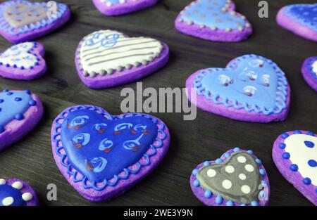 Tas de coeur bleu et violet en forme de beaux biscuits glacés royaux à motifs Banque D'Images