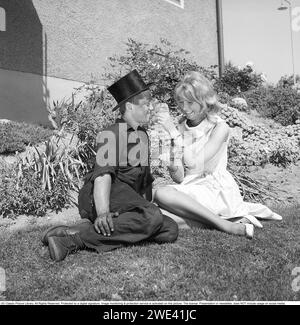 Chocolat Mazetti. Un jeune couple assis sur une journée ensoleillée d'été et elle offre dim un morceau de chocolat de sa barre de chocolat. Suède 1962. Kristoffersson réf CZ54 Banque D'Images