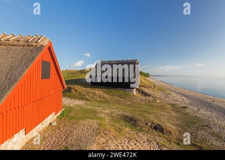 Deux cabanes de pêche au lever du soleil en été le long de la côte de la mer Baltique à Havaeng / Haväng, Österlen / Oesterlen, Skane / Scania, Suède Banque D'Images