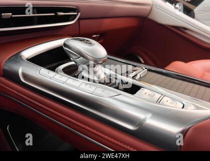Levier de vitesses automatique d'une voiture moderne. Détails intérieurs modernes. Gros plan. Voiture à l'intérieur. Levier de changement de vitesse de transmission automatique. Intérieur en cuir rouge Banque D'Images