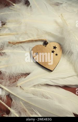 Décoration en bois coeur et plumes blanches Banque D'Images