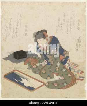 Femme fait une peinture sur sable, Utagawa Kunisada (I), 1820 estampe Une femme assise (acteur Segawa Kikunojô V (1802-32) dans un rôle de femme inconnu) fait une peinture sur sable sur une feuille de peinture. À côté de la peinture, il y a deux cuillères, une spatule en bois et une boîte de laque sur la gauche. Le tableau représente la montagne de Fuji, vue depuis la plage de Matsu No Shimabara. Le nuage à côté de Fuji, en forme de dragon, fait référence à la nouvelle année du dragon. Faire des peintures sur sable était une disposition de temps bien-aimée pour les femmes des années 1920 du XIXe siècle, peut-être avant. Avec deux poèmes. Papier japonais Banque D'Images