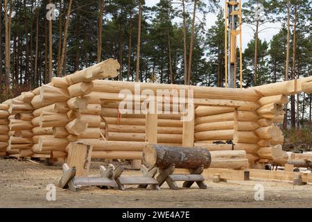 Le chantier de construction d'une maison en bois. Cabane en rondins traditionnelle construite à partir de bûches de bois lors d'une journée ensoleillée d'été. Design de maison cottage Banque D'Images