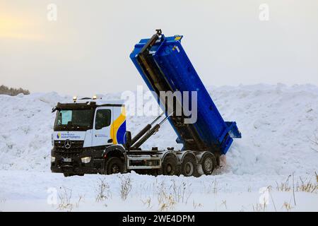 Le camion benne basculante Mercedes-Benz décharge la neige déneigée des rues et des stationnements de la zone municipale de déversement de neige. Salo, Finlande. 19 janvier 2024. Banque D'Images