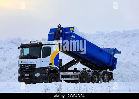 Le camion benne basculante Mercedes-Benz décharge la neige déneigée des rues et des stationnements de la zone municipale de déversement de neige. Salo, Finlande. 19 janvier 2024. Banque D'Images