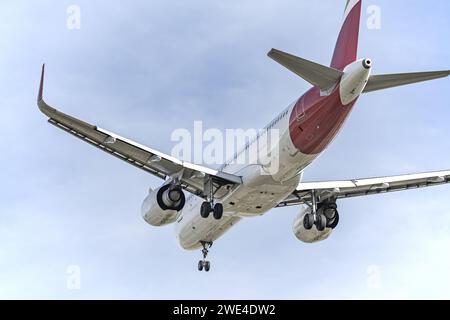 Vue du fuselage arrière d'un avion de passagers avec train d'atterrissage déployé approchant d'une piste d'aéroport Banque D'Images