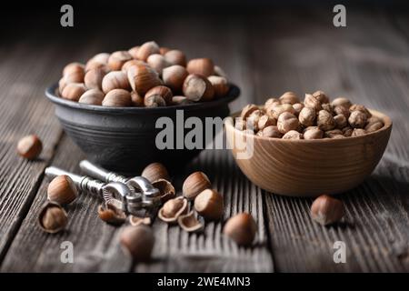 Noisettes ouvertes avec un casse-noisette argenté classique, présenté sur une table en bois antique dans cette photographie culinaire captivante Banque D'Images