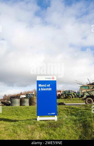 Montauban, France. 23 janvier 2024. Un panneau, Vinci, Merci et à bientôt, avec des balles de paille et des tracteurs en arrière-plan. La FNSEA et les jeunes agriculteurs du Tarn-et-Garonne rassemblent et bloquent à Montauban l'autoroute A20. France, Golfech 23 janvier 2024. Photo de Patricia Huchot-Boissier/ABACAPRESS.COM crédit : Abaca Press/Alamy Live News Banque D'Images