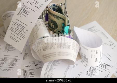 Un tas de dollars AMÉRICAINS dans un chariot entouré de nombreux reçus en papier se rapprochent Banque D'Images