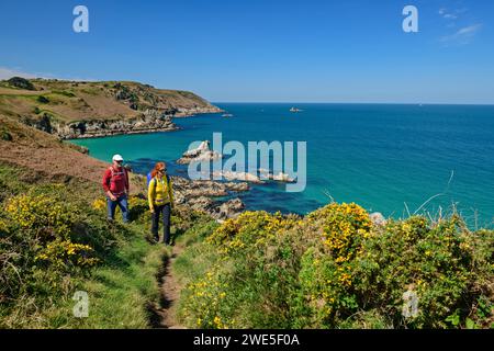 Homme et femme randonnant sur le Zöllnerweg au Cap Sizun avec la mer et les îles rocheuses en arrière-plan, Cap-Sizun, GR 34, Zöllnerweg, Bretagne, France Banque D'Images