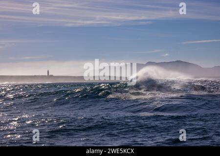 Vague de rupture dans l'Atlantique Sud avec vue sur le phare de danger point, près de Gansbaai, Western Cape, Afrique du Sud Banque D'Images