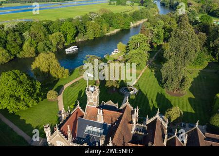 Vue aérienne d'une péniche le Boat Horizon 4 passant devant l'Oakley court Hotel le long de la Tamise, Water Oakley, près de Windsor, Berkshire, Angleterre, ONU Banque D'Images