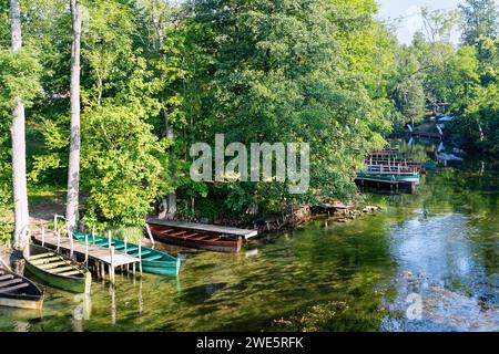 Rivière Krutynia et bateaux en bois à l'embarcadère sur la rive de Krutyń en Mazurie (Mazury) dans la voïvodie de Warmińsko-Mazurskie en Pologne Banque D'Images