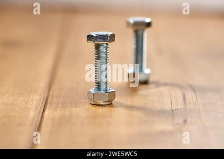 Deux vis filetées sur table en bois. Banque D'Images