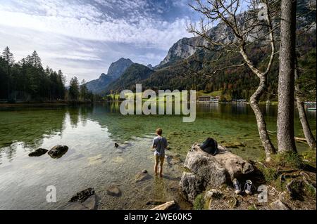 Vue de Hintersee, jeune homme debout dans le lac, chaussures debout sur le rivage, chemin mural, sentier de la nature sur le ruisseau / rivière Ramsauer Ache, randonnée dans t Banque D'Images