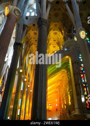 Intérieur de la basilique de la Sagrada Familia éclairé par la lumière colorée passant à travers les vitraux Banque D'Images