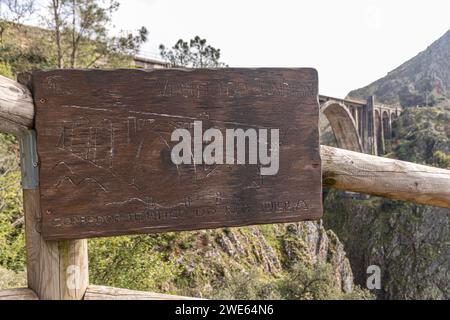 A Ponte Ulla, Espagne. Plaque sculptée en bois du viaduc de Gundian, pont ferroviaire en pierre et en fer sur la rivière Ulla Banque D'Images