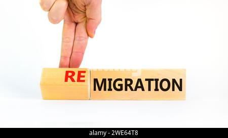 Symbole de migration ou de remigration. Mot concept migration Remigration sur de beaux cubes en bois. Beau fond blanc. Main d'homme d'affaires. Entreprise Banque D'Images