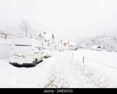 Paysage hivernal au village Nydek à Morsavskoslezske Beskydy et voitures enneigées Banque D'Images