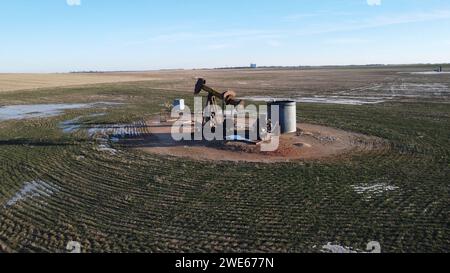 L'invention concerne un puits de pétrole situé sur un champ de terre compact adjacent à des réservoirs de stockage d'eau Banque D'Images