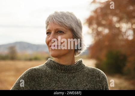 Femme mature souriante portant un pull Banque D'Images