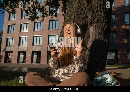 Happy Woman aime écouter de la musique avec des écouteurs sans fil Banque D'Images