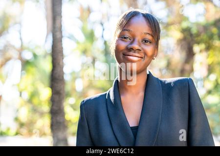Femme souriante portant un blazer au parc Banque D'Images