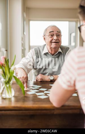 Grand-père et petit-fils jouant aux cartes à la maison Banque D'Images