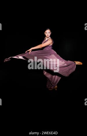 Adolescente exécutant de la danse flamenco sur fond noir Banque D'Images