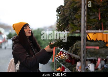 Belle femme achetant la couronne au marché de Noël Banque D'Images