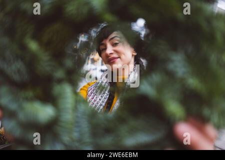 Femme souriante regardant à travers la couronne Banque D'Images