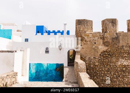 Mur lapidé près des maisons par jour ensoleillé Banque D'Images