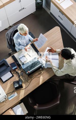 Collègues d'affaires multiracial planifiant la stratégie assis au bureau dans le bureau Banque D'Images