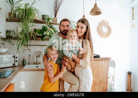 Portrait de famille avec deux fils dans la cuisine à la maison Banque D'Images