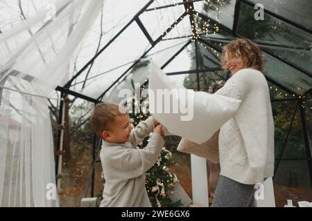 Heureux mère et fils ayant combat d'oreiller à la maison Banque D'Images