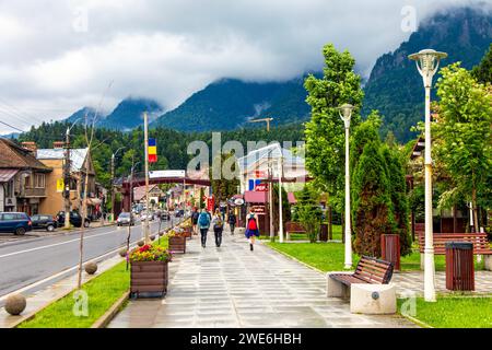 La rue principale Bulevardul Libertății avec des stands de vendeurs et vue sur les montagnes Bucegi, Busteni, Roumanie Banque D'Images