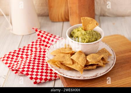 Guacamole. La sauce DIP à l'avocat, l'une de ses nombreuses façons de la consommer, est étalée sur des chips tortilla également appelées Nachos. Recette de sauce maison facile mexicaine Banque D'Images