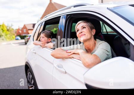 Jour mère et fille rêvant assis dans la voiture Banque D'Images