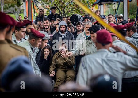 Les personnes en deuil pleurent lors de la cérémonie funéraire du major Ilay Levi au cimetière militaire de tel Aviv. Le commandant, Ilay Levi, 24 ans, a été tué au combat dans le sud de la bande de Gaza. Vingt-quatre soldats israéliens ont été tués à Gaza lundi, de loin le plus grand nombre de morts israéliens en une journée dans la guerre de trois mois contre le Hamas, alors que les pourparlers sur un cessez-le-feu s’intensifiaient et que les pertes palestiniennes continuaient d’augmenter. Les morts sont survenues dans un contexte de combats acharnés autour de la ville méridionale de Khan Younis, avec des dizaines de Palestiniens tués et blessés. Les pertes israéliennes sont susceptibles d'accroître la pression intérieure sur Benjamin Banque D'Images