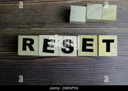 Concept des cubes en bois avec le mot Reset sur fond en bois. Banque D'Images