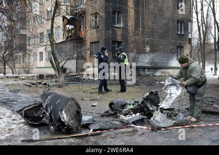 Un membre de l'escouade examine des fragments d'une roquette russe près d'un bâtiment résidentiel endommagé à la suite d'une attaque russe à Kiev. Au moins 21 personnes ont été blessées après que des tirs de missiles russes aient frappé Kiev, selon les services d’urgence ukrainiens. Banque D'Images