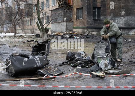 Un membre de l'escouade examine des fragments d'une roquette russe près d'un bâtiment résidentiel endommagé à la suite d'une attaque russe à Kiev. Au moins 21 personnes ont été blessées après que des tirs de missiles russes aient frappé Kiev, selon les services d’urgence ukrainiens. Banque D'Images