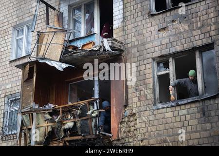 Kiev, Ukraine. 23 janvier 2024. Les gens retirent les débris de leur immeuble endommagé après une attaque à la roquette à Kiev. Au moins 21 personnes ont été blessées après que des tirs de missiles russes aient frappé Kiev, selon les services d’urgence ukrainiens. (Photo Oleksii Chumachenko/SOPA Images/Sipa USA) crédit : SIPA USA/Alamy Live News Banque D'Images