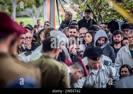 Les personnes en deuil pleurent lors de la cérémonie funéraire du major Ilay Levi au cimetière militaire de tel Aviv. Le commandant, Ilay Levi, 24 ans, a été tué au combat dans le sud de la bande de Gaza. Vingt-quatre soldats israéliens ont été tués à Gaza lundi, de loin le plus grand nombre de morts israéliens en une journée dans la guerre de trois mois contre le Hamas, alors que les pourparlers sur un cessez-le-feu s’intensifiaient et que les pertes palestiniennes continuaient d’augmenter. Les morts sont survenues dans un contexte de combats acharnés autour de la ville méridionale de Khan Younis, avec des dizaines de Palestiniens tués et blessés. Les pertes israéliennes sont susceptibles d'accroître la pression intérieure sur Benjamin Banque D'Images