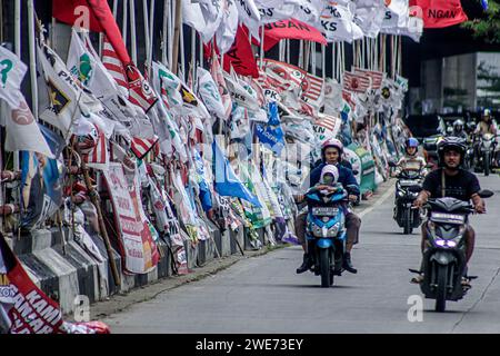 Des véhicules publics passent devant des centaines de médias visuels de campagne à Bogor City, Java Ouest, Indonésie, le 23 janvier 2024 Banque D'Images