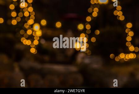 Image floue des lumières de Noël jaunes sur les arbres à feuilles persistantes à l'extérieur en Corée du Sud Banque D'Images